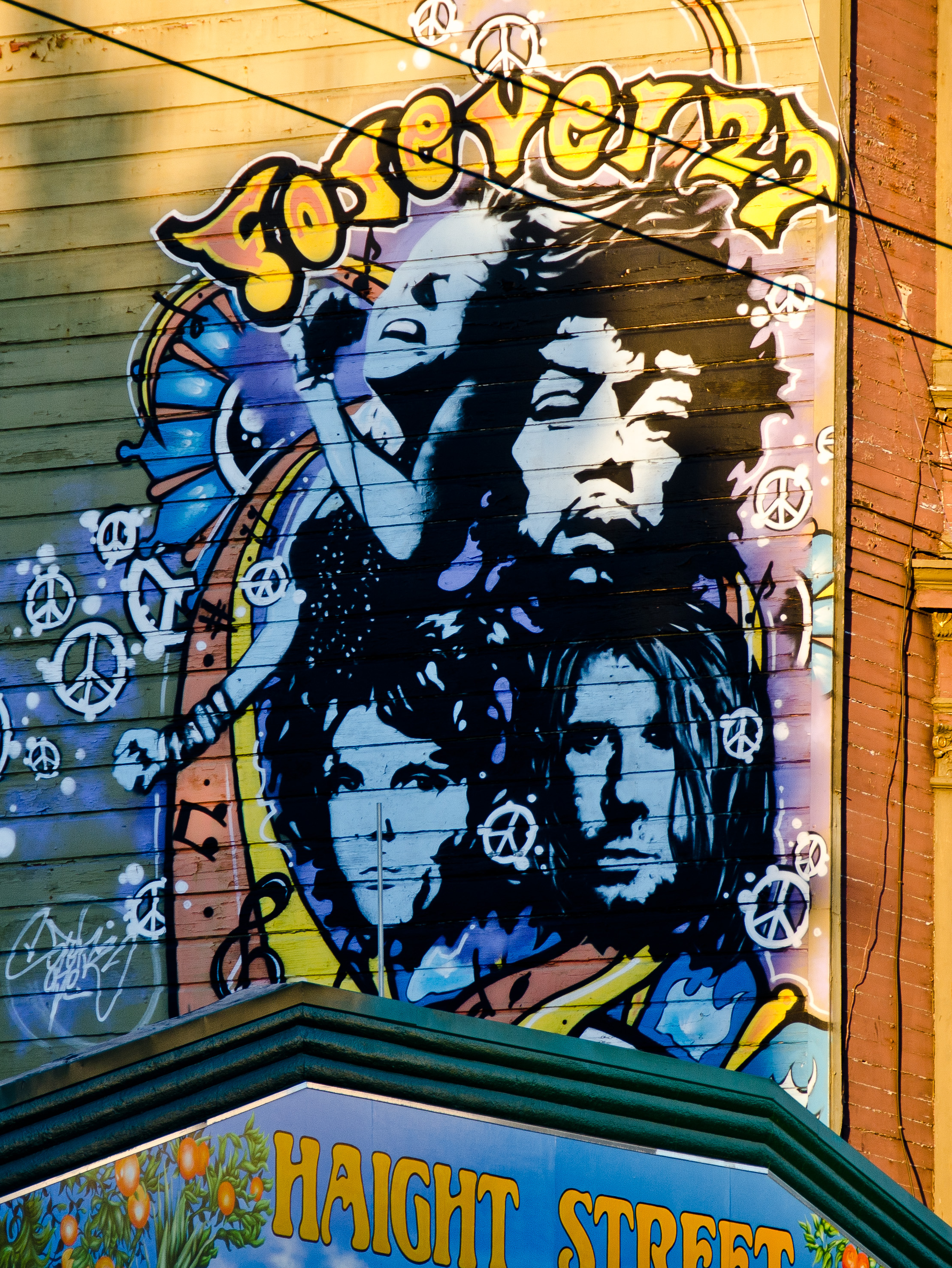 Graffiti von Jimi Hendrix, Brian Jones, Janis Joplin und Jim Morrison an einer Hauswand.