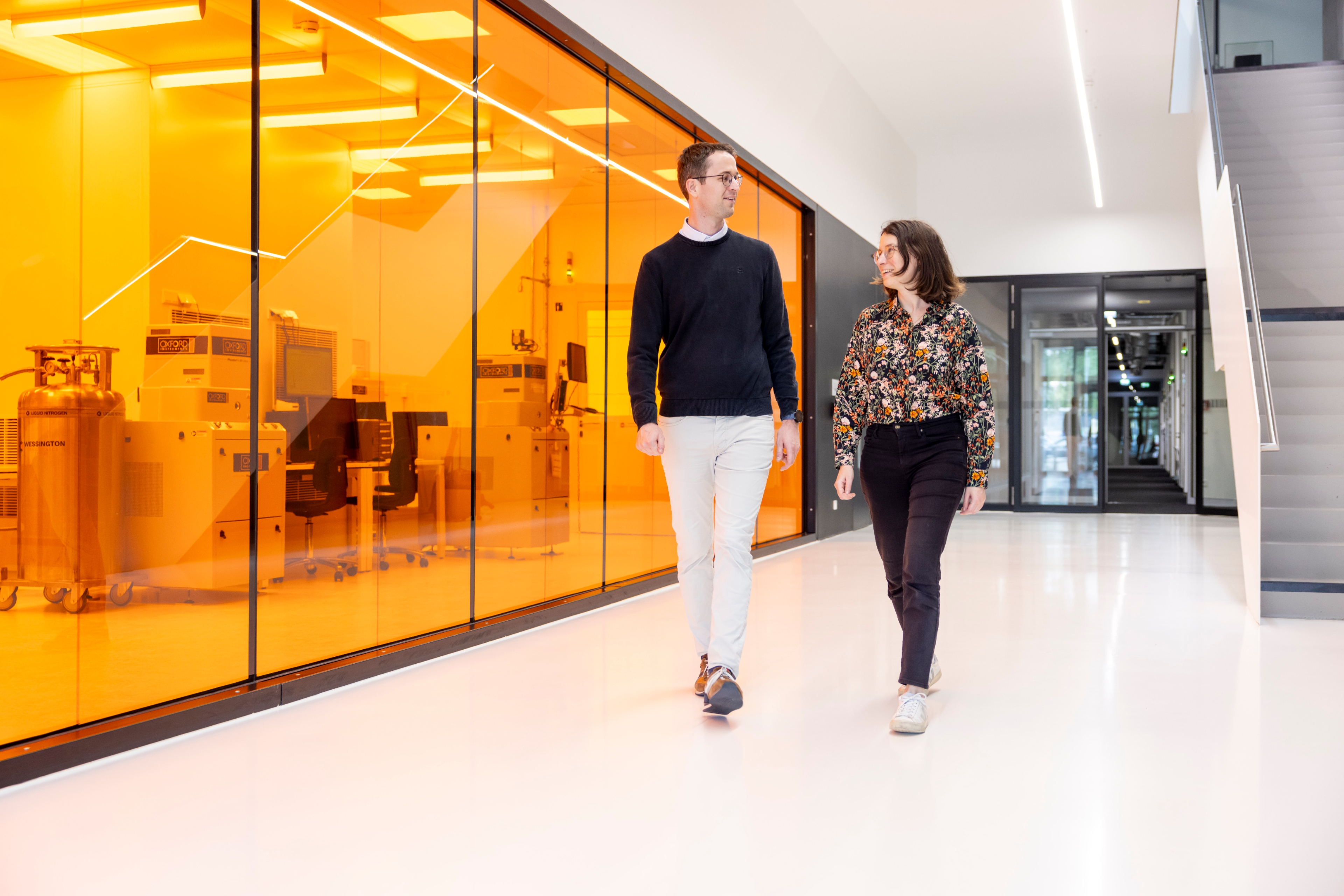 Two yound scientist walking down a corridor.